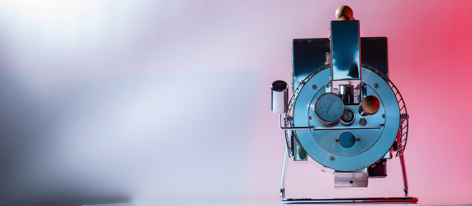 a photo of quest home roaster placed in a pink and white background