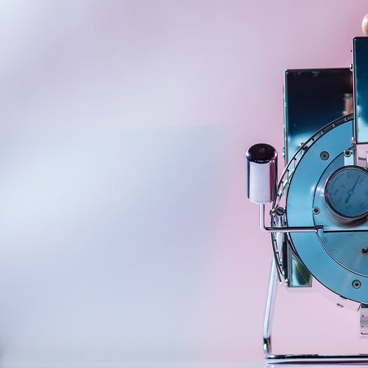 a photo of quest home roaster placed in a pink and white background